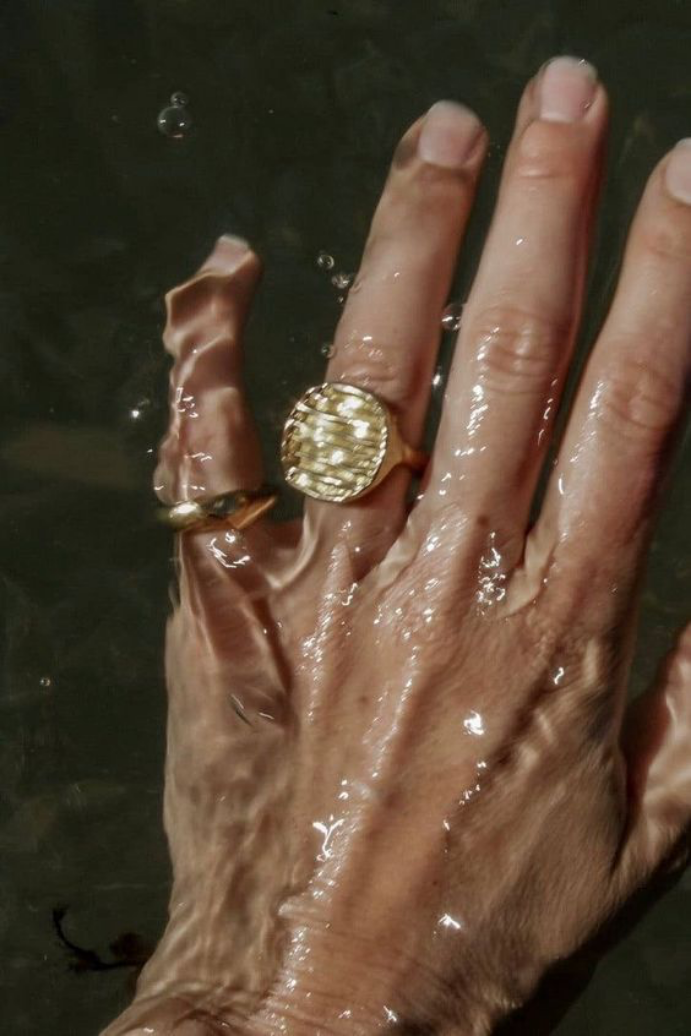 hand with gold rings in water
