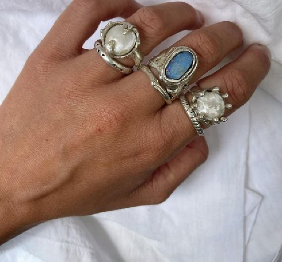 hand with silver chunky stone rings